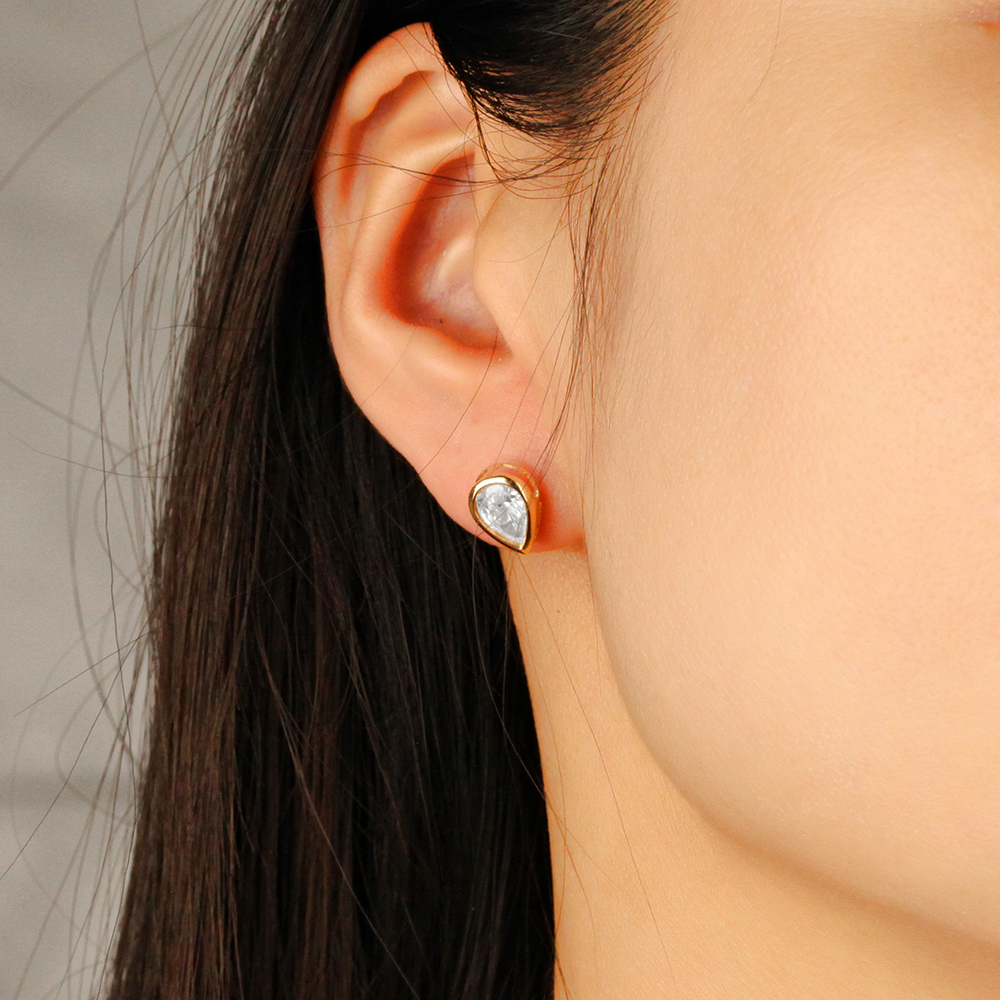 B100512OE-XDC-4Y-F-wear.jpg Bezel-Set Pear Shape Diamond Stud Earrings - Image 1